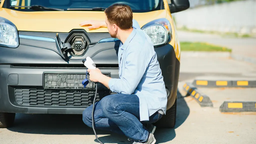 Smiling man unplugging the charger from the car